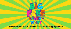 Colorful banner featuring vibrant yellow and green rays, text reads "THE BIG FREE GAMING DAY!" with date and location below.